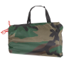 Studio product shot of the Woodland camouflage tarpaulin packed securely inside its matching transport drawstring bag.