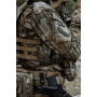 Tactical action shot showcasing the pouch mounted on the side cummerbund or platform of a plate carrier.